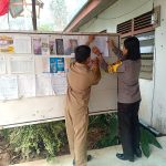 Bripda Ona Tempelkan Selebaran Himbauan Kamtibmas di Kantor Desa Suka Gerundi