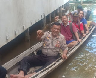 Dengan Perahu Kecil Kapolsek Batang Tarang Sambang ke Desa yang Terkena Banjir