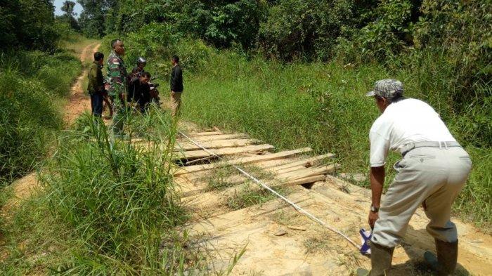 Satgas TMMD Kodim 1204/Sanggau Bersama Warga Ukur Secara Manual Jembatan yang Bakal Diperbaiki