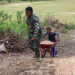 Anggota Satgas dan warga gotong royong pindahkan material bangunan