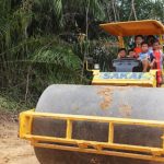 Anak-anak bersuka ria bermain di alat berat terparkir