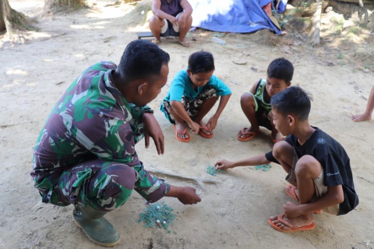 Manfaatkan waktu luang, prajurit TMMD bermain kelereng bersama anak-anak
