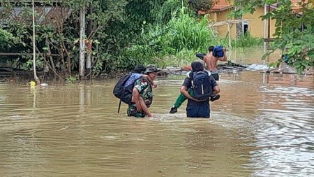 Babinsa Koramil Entikong Bantu Siswa dan Warga Lewati Banjir