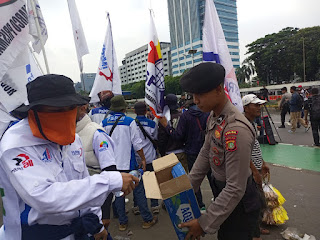 Aksi Simpatik, Polisi Bagikan Air Mineral dan Roti kepada Buruh di Depan DPR/MPR